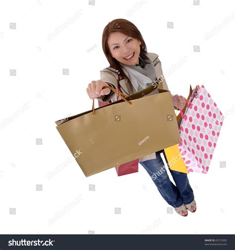 Happy Shopping Woman Show Her Bags And Smiling Isolated Over White