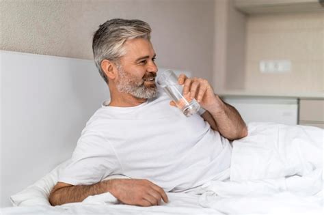 Premium Photo Cheerful Middle Aged Man Drinking Water After Waking Up