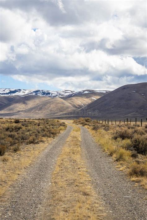 A Long Straight Road Heading Into The Distant Mountains Stock Photo