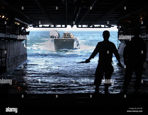 Us Navy Sailors Guide A Landing Craft Utility Boat Into The Flooded Well Deck Of The Uss