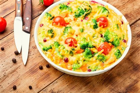 Cazuela de verduras con brócoli tomate y calabaza en la mesa de madera