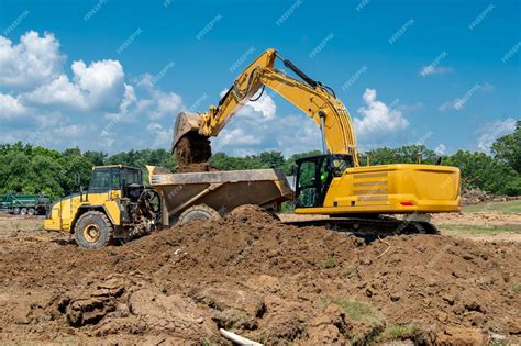 Premium Photo Excavation And Loading Into Dump Trucks With Excavator