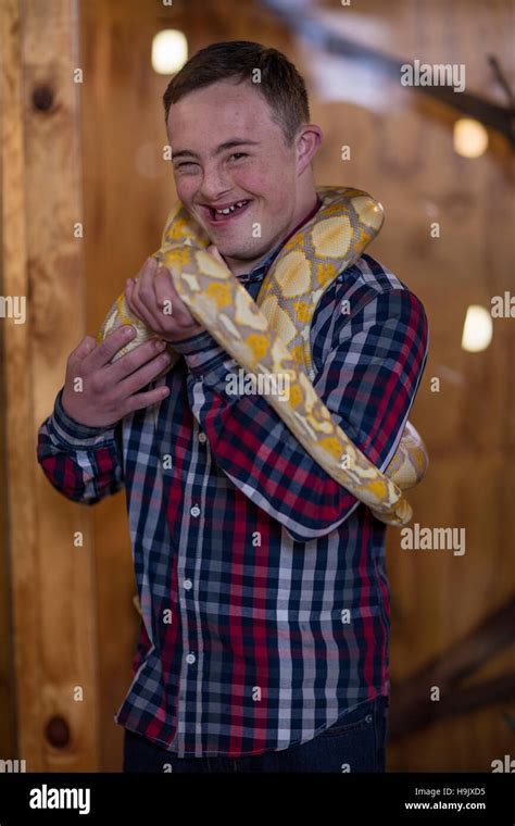 Young man with down syndrome holding albino python snake Stock Photo - Alamy