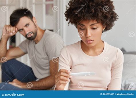 Image Of Serious Black Woman Finds Out About Pregnancy Holds Test In