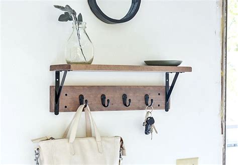 a wooden shelf with hooks and keys on it next to a white bag hanging from the wall