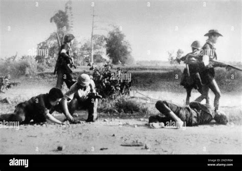 Communist Viet Cong Guerrillas Move Past Two Trussed Prisoners