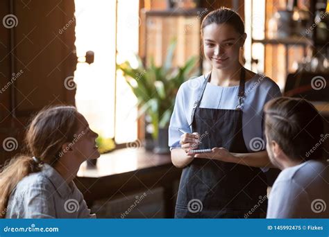 Smiling Waitress Serving A Married Couple Take Order Stock Image