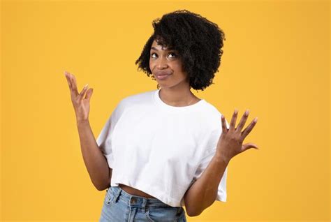 Sorprendida Y Confundida Joven Negra Rizada Con Camiseta Blanca