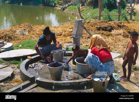 Indian Women Washing Clothes At Village Hand Pump Tharu Village Stock