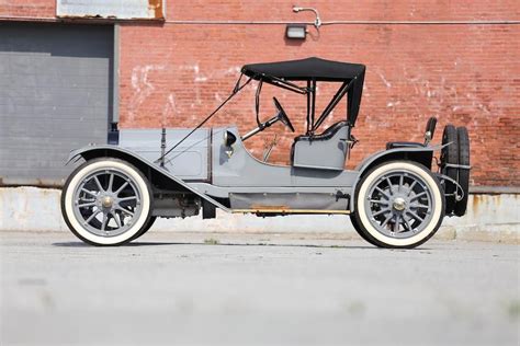 An Old Model T Car Parked In Front Of A Brick Building