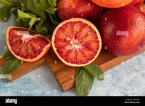 Sliced And Whole Ripe Juicy Sicilian Blood Oranges On Wooden Cutting