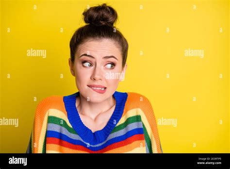 Photo Of Cute Sweet Brunette Girl Looking Empty Space Bite Lips Wear Rainbow Sweater Isolated On