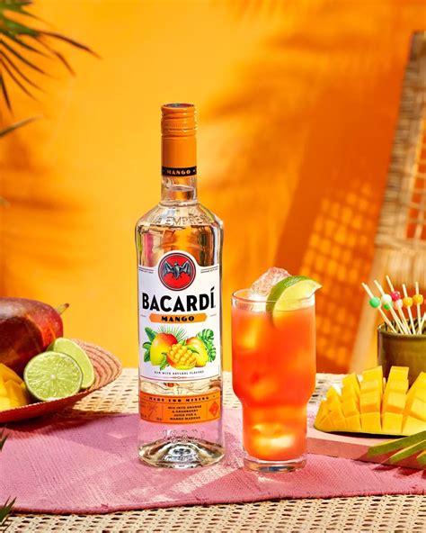 A Bottle Of Bacardi Next To A Glass And Plate With Fruit