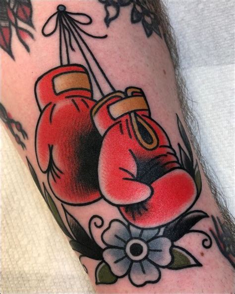 A Tattoo With Two Boxing Gloves On It S Arm And Flowers Around The Wrist