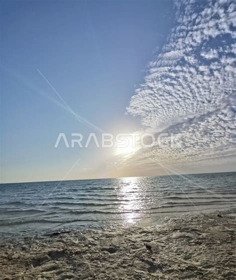 صورة للغيوم تغطي الشمس على شاطئ البحر في السعودية، منظر جمالي للغيوم في