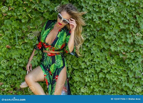 Hot Blonde Brazilian Model Posing Outdoors Against A Field Of Plants