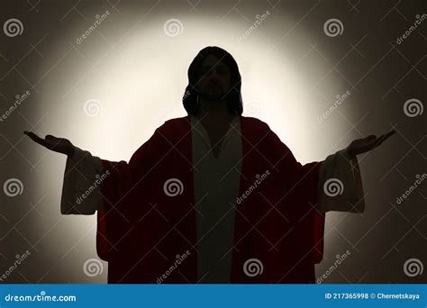 Silhouette Of Jesus Christ With Outstretched Arms On Color Background