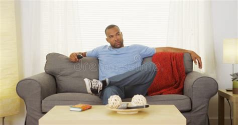 Black Man Sitting On Couch Watching Tv Stock Photo - Image: 47558360