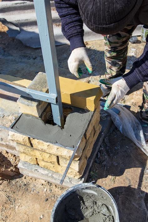 El Hombre Construye Una Pared De Ladrillo En Un Emplazamiento De La