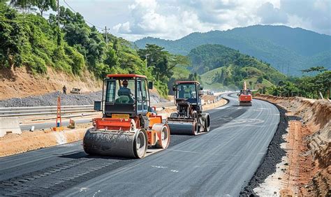 A Bulldozer Is Driving Down A Road With A Mountain In The Background