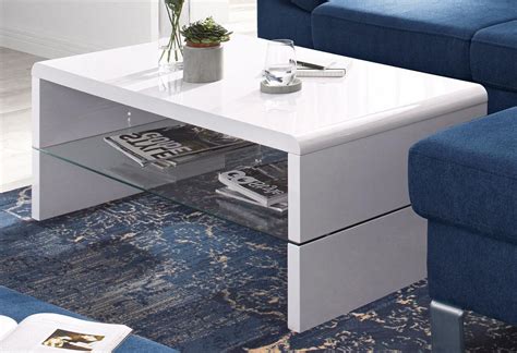 A White Coffee Table Sitting On Top Of A Blue Rug