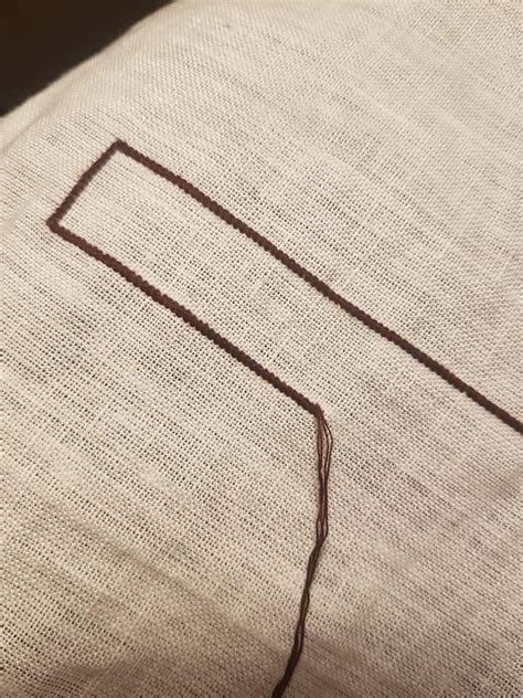 A Close Up Of A Pillow With A Square Stitched In To It S Side