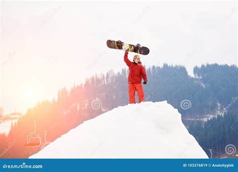 Man Snowboarder Standing On The Top Of The Snowy Hill With Snowboard In