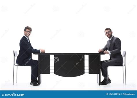 Two Business People Discussing Something Sitting At The Table Stock