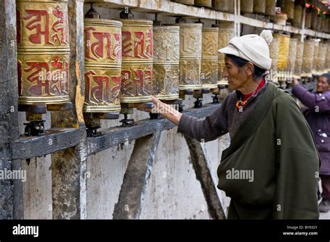 Tibetan Man Pilgrim Spinning Prayer Wheels Outside Mani Lhakhang In The