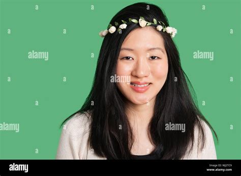 Portrait Of A Beautiful Young Woman Wearing A Hair Wreath Over Green