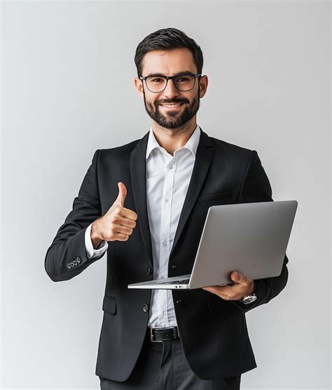 Un hombre en traje con una computadora portátil y pulgares hacia arriba