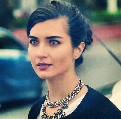 A Woman With Black Hair Wearing A Necklace And Dress On The Street In