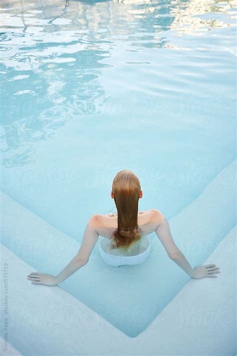 Woman Relaxing In A Pool At Luxury Resort And Spa By Stocksy