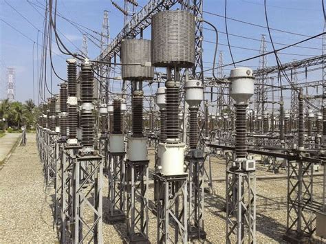 an array of electrical substations in the middle of a road with power lines overhead