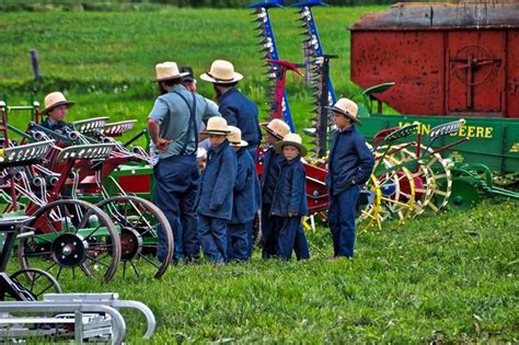 a group of men standing next to each other in front of farm equipment