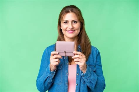 Mujer caucásica de mediana edad sosteniendo una billetera sobre un