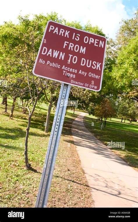 Sign In A City Park Reading Park Is Open From Dawn To Dusk Stock Photo