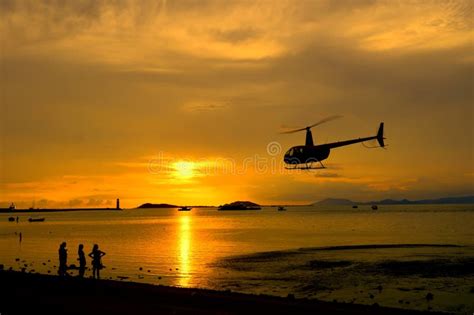 Silhouetted Helicopter Flying Across A Sunset Sky Stock Photo - Image ...