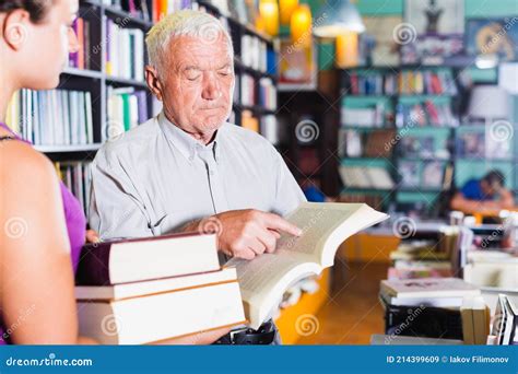 Grandfather With Young Granddaughter Are Reading Books Stock Image