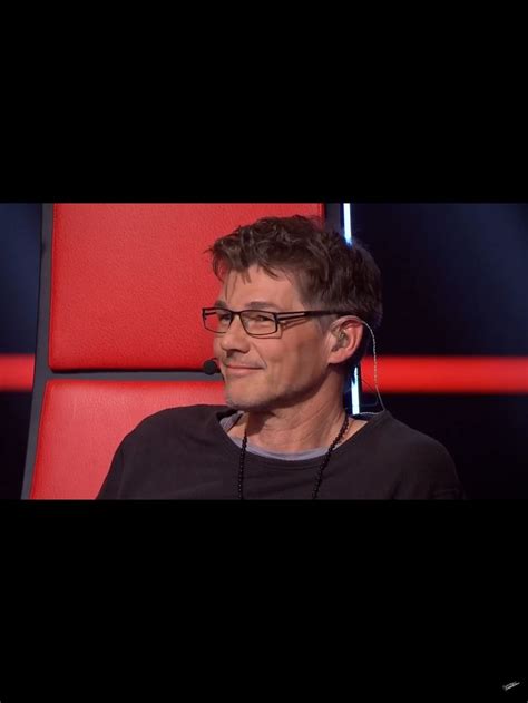 A Man Wearing Glasses Sitting In A Red Chair