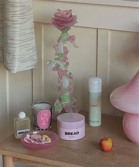 A Wooden Table Topped With Pink Flowers And Personal Care Items Next To