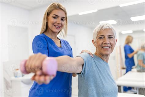 Professional therapists is stretching muscles, senior patient with