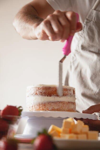 Premium Photo A Man Cutting A Cake With A Knife And A Knife