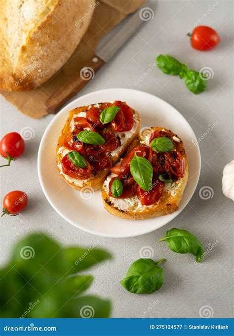 Bruschetta With Ricotto Cheese And Cherry Tomatoes Basil Garlic On A Grey Concrete Background