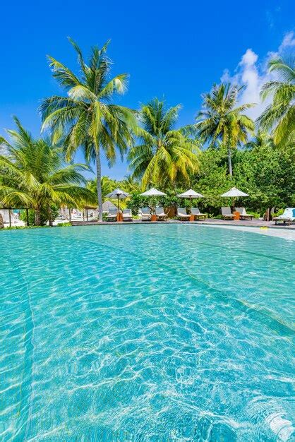 Luxus infinity pool mit liegestühlen und palmen über weißem sand