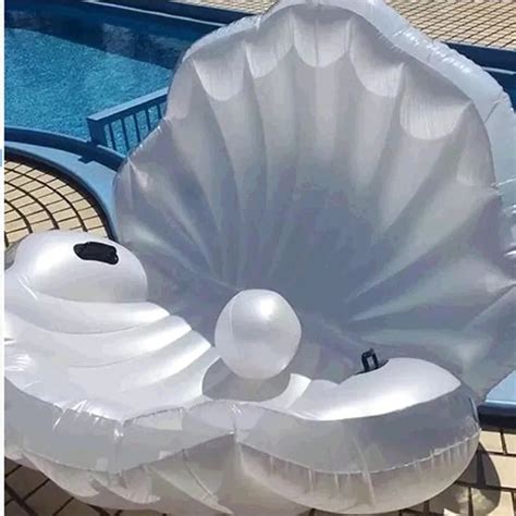 an inflatable shell is sitting on the ground next to a swimming pool