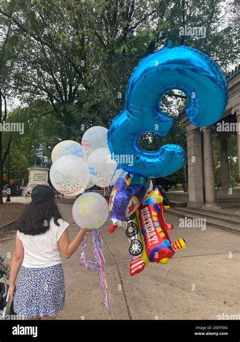 Woman Walks Into Prospect Park With A Bouquet Of Balloons For What Looks Like A Three Year Olds