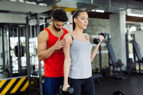 Mujer Adulta Joven Que Se Resuelve En Gimnasio Con El Instructor Foto