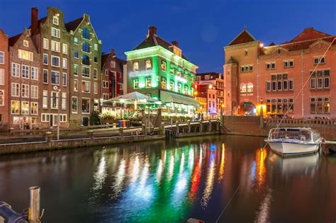 Premium Photo | Amsterdam canal damrak at night holland netherlands