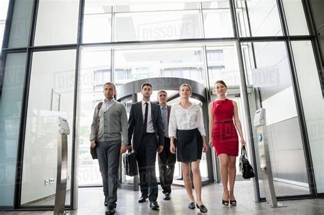 Group of business people walking into glass office building - Stock ...